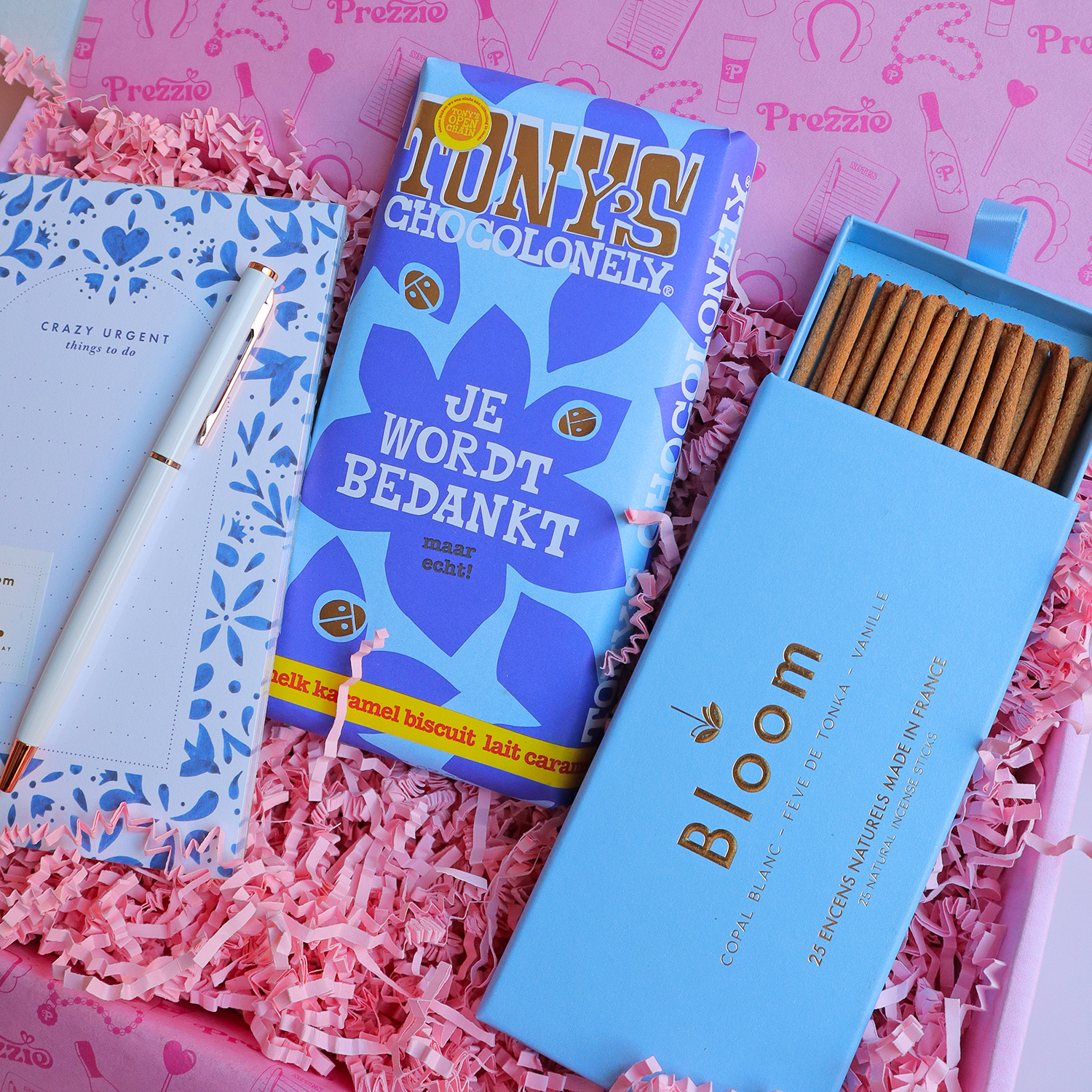 Luxe bedankcadeaubox met Tony’s Chocolonely “Je wordt bedankt”-reep, notitieblok met pen en Bloom wierooksticks in roze Prezzie verpakking.