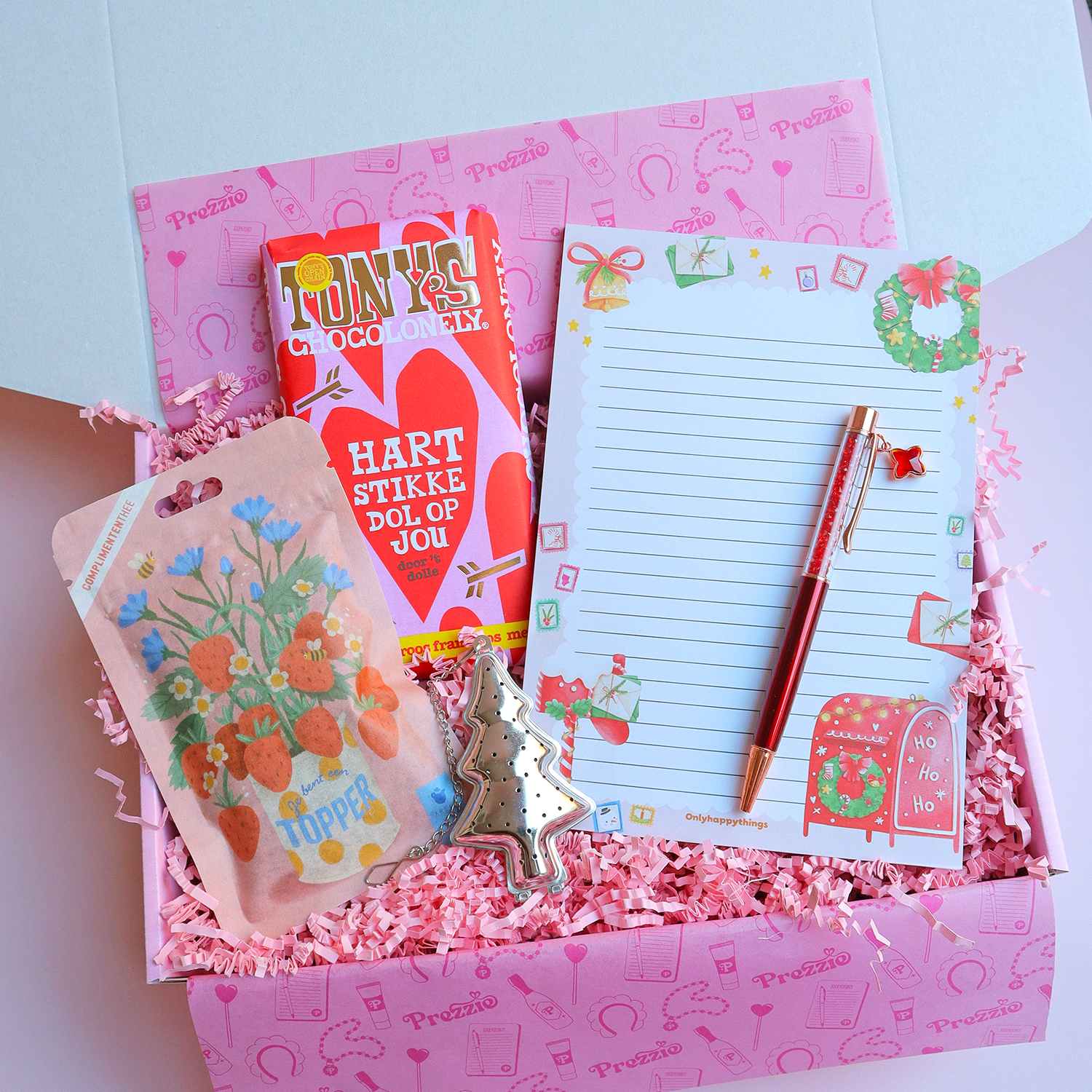 Kerstcadeaubox met Tony’s “Hartstikke dol op jou”-reep, kerstnotitieblok met pen, bloemenzaadjes en kerstboomhanger in roze Prezzie verpakking.