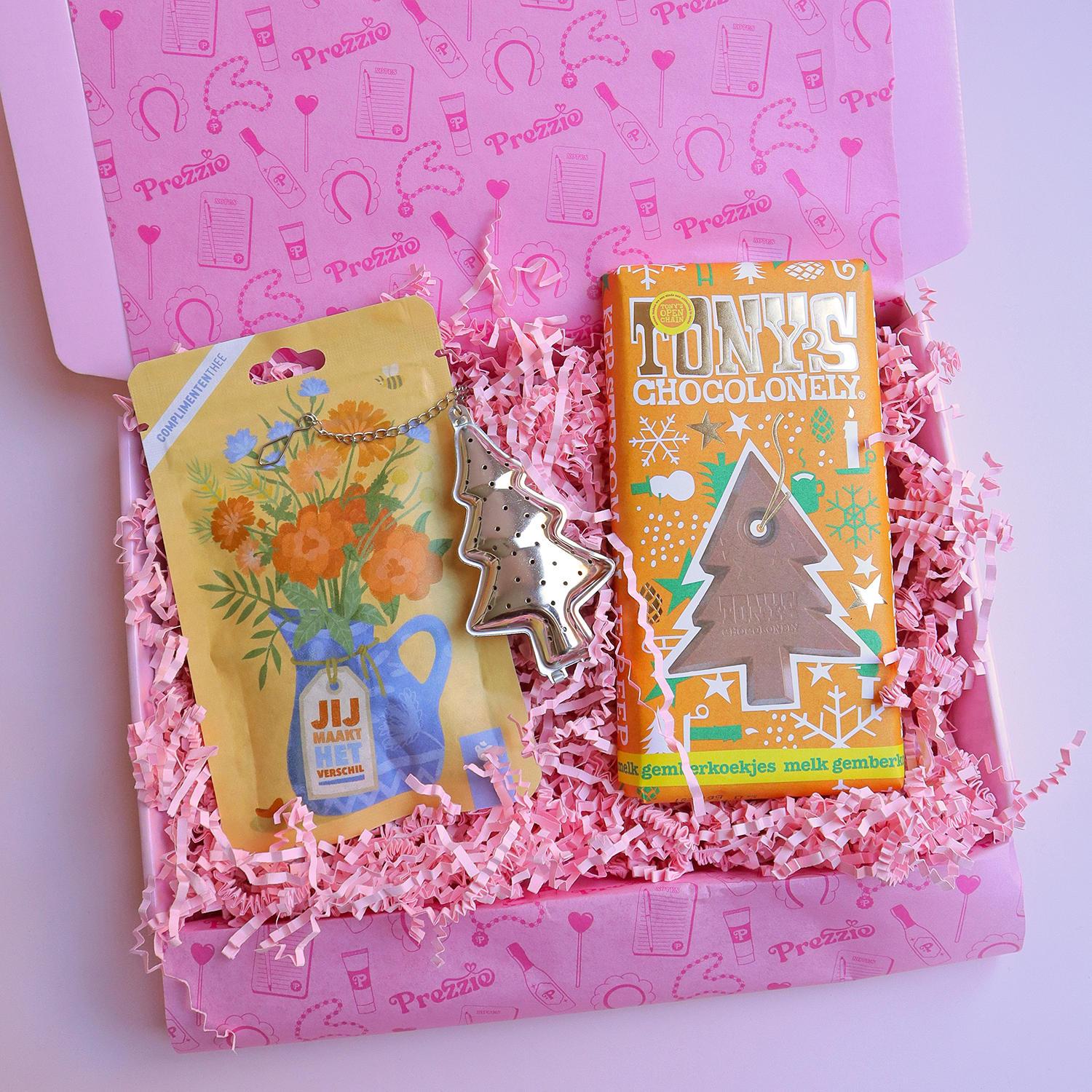 Brievenbus kerstcadeau met Tony’s Chocolonely kerstreep, Jij maakt het verschil thee en kerstboom-theezeef in roze Prezzie verpakking.