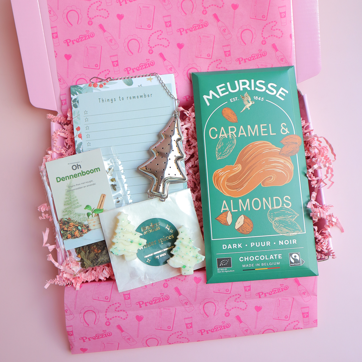 Brievenbus kerstcadeau met Meurisse chocoladereep, Oh Dennenboom thee, kerstboom waxmelts, theezeef en kerstnotitieblok in roze Prezzie verpakking.