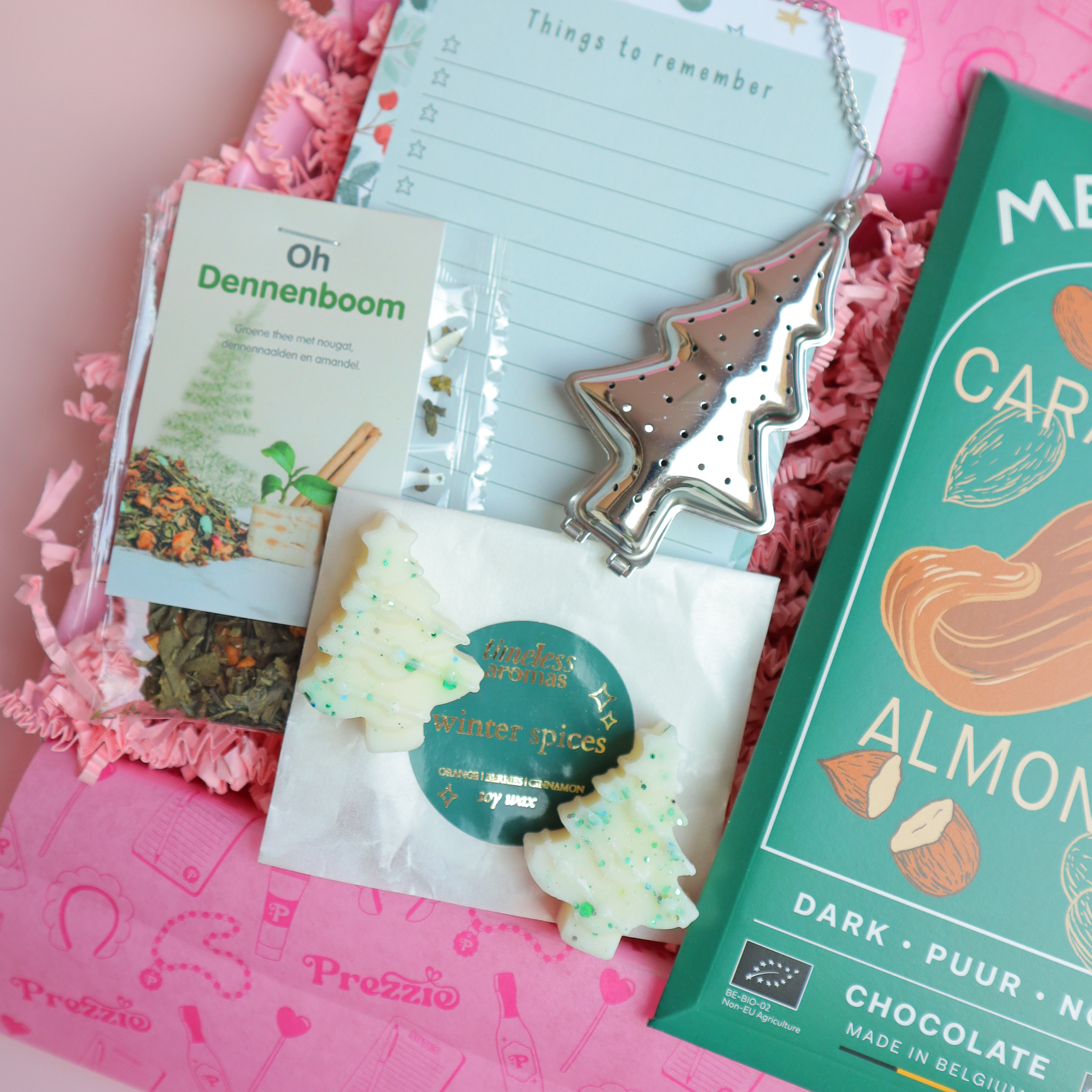 Brievenbus kerstcadeau met Meurisse chocoladereep, Oh Dennenboom thee, kerstboom waxmelts, theezeef en kerstnotitieblok in roze Prezzie verpakking.