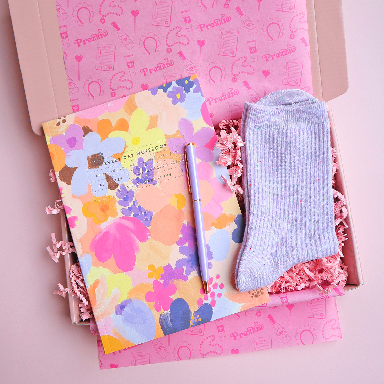 Brievenbuscadeau met kleurrijk A5 notitieboek, pen en zachte sokken in roze Prezzie cadeaubox