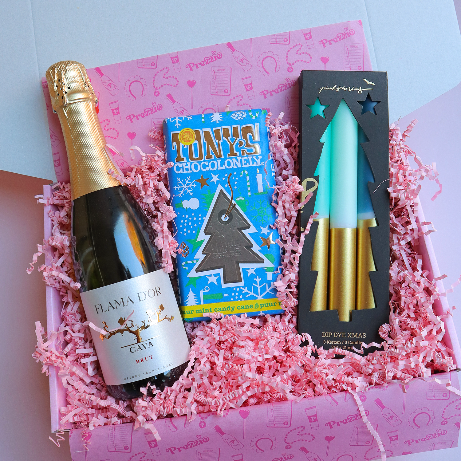 Luxe kerstcadeaubox met fles cava, Tony’s Chocolonely kerstchocolade en dip dye kerstkaarsen in roze cadeauverpakking van Prezzie.