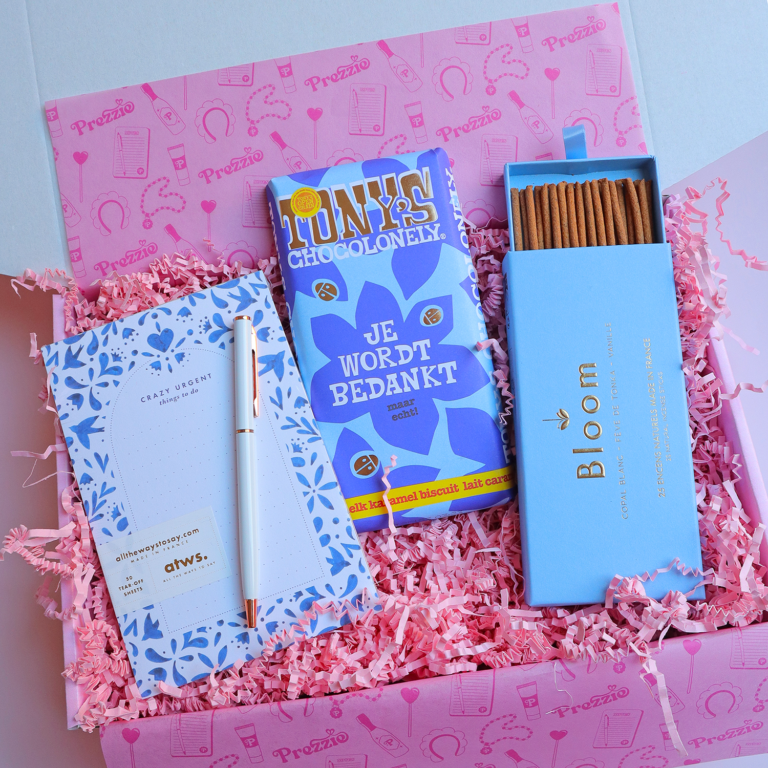 Luxe bedankcadeaubox met Tony’s Chocolonely “Je wordt bedankt”-reep, notitieblok met pen en Bloom wierooksticks in roze Prezzie verpakking.