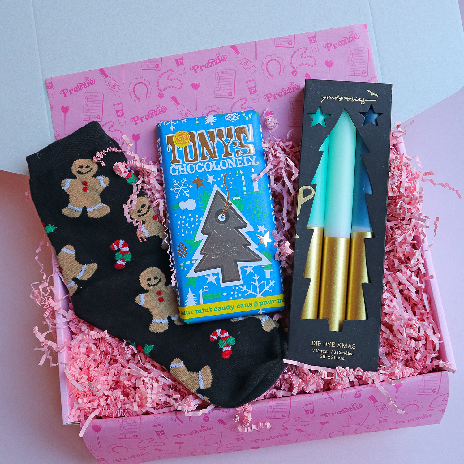 Kerstcadeaubox met gingerbread sokken, Tony’s Chocolonely kerstreep en dip dye kerstkaarsen in roze Prezzie verpakking.