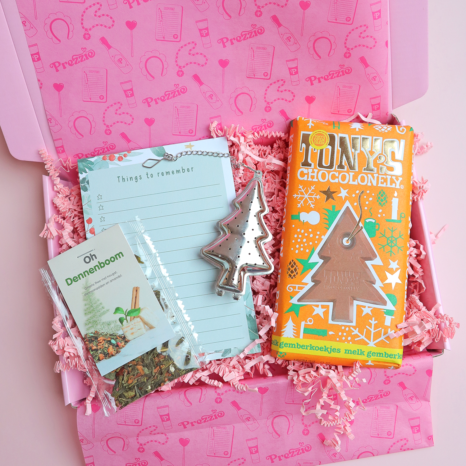 Brievenbus kerstcadeau met Tony’s kerstreep, Oh Dennenboom thee, notitieblok en kerstboom-theezeef in roze Prezzie verpakking.